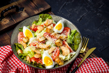  Caesar salad with chicken and eggs on a plate close-up