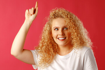 Young attractive blonde woman pointing her finger to copy space