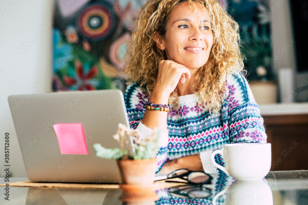 Wall mural portrait of beautiful blonde caucasian woman smile and work with laptop computer at home - concept o