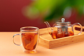 Glass teapot and cup with black tea