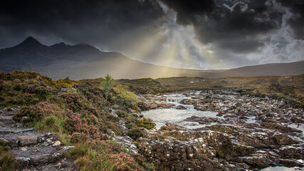 A stormy sky with sun beams over the river Sligachan on the Isle of Skye in Scotland