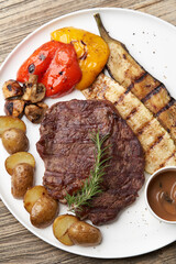 Ribeye steak with fried potatoes. Baked vegetables with beef steak on white plate