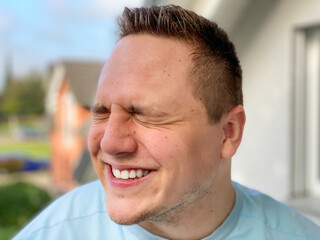 Charismatic young man screwing up his eyes