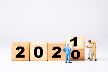 Miniature worker flipping wooden cubes block for change 2020 to 2021 , Welcome new year concept.
