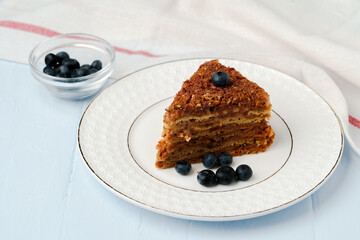 Piece of honey cake with nuts on white plate