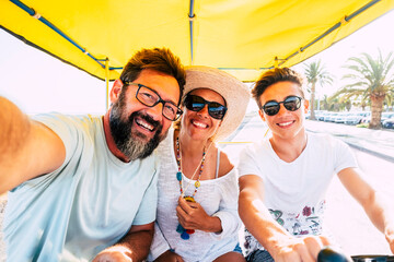 Happy caucasian family enjoy bike leisure activity outdoor together having lot of fun and laughing - holiday vacation for group of three people father mother and young teenager son - cheerful family