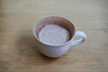 Cocoa drink in white mug on brown wooden table