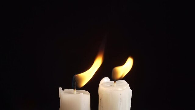 Footage of burning a two candles on black background