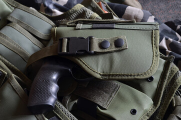 Fototapeta na wymiar Tactical unloading vest with magazines and integrated holster - selective focus 