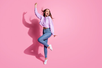 Full body photo of enjoy rejoice girl have free time look copyspace raise hand wear trendy lilac pullover sneakers hair fly isolated over pastel color background