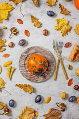 Autumn still life  flat lay. Pumpkins, plums, fallen leaves, acorns, chestnuts on a blue background, top view. Autumn harvest concept, thanksgiving day background, 
view from above