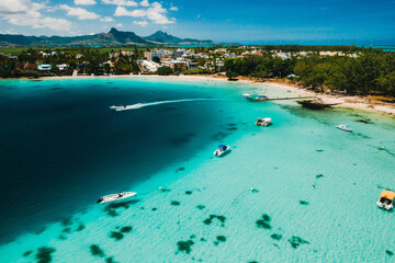Fototapeta na wymiar Aerial photography of the East coast of the island of Mauritius. the blue lagoon of the island of Mauritius is shot through from above. The boat is floating on a turquoise lagoon