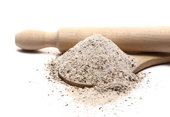Buckwheat flour with wooden spoon and kitchen rolling pin isolated on white background