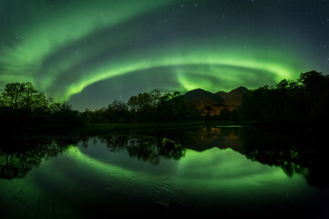 Beautiful night sky with Aurora Borealis aka northern lights in the fjords in Norway.