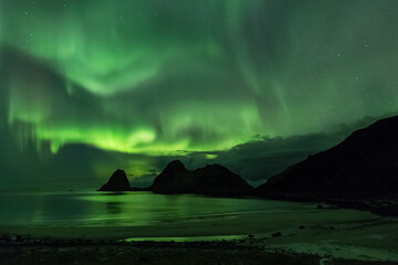 Beautiful night sky with Aurora Borealis aka northern lights in the fjords in Norway.