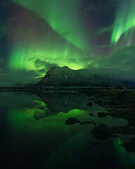 Beautiful night sky with Aurora Borealis aka northern lights in the fjords in Norway.