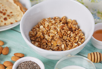breakfast with home made granola and pancakes on turquoise surface