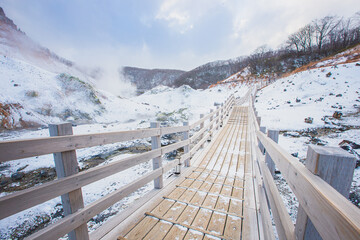 Wooden path of Jigokudani or hell valley in Noboribetsu, Hokkaido, Japan In winter. - obrazy, fototapety, plakaty