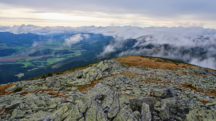 View into the valley with clouds rolling over the mountain ridge surrounding it, Low Tatras, Slovakia.