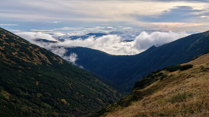 Naklejka na ściany i meble Beautiful view on clouds rolling over mountain ridges, Low Tatras, Slovakia.