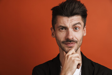 Photo of confident handsome man looking at camera and touching his chin