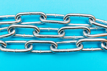 Top view Close-up metal chain lies on the blue background .Studio shot.