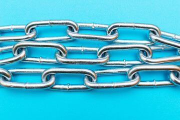 Fototapeta premium Top view Close-up metal chain lies on the blue background .Studio shot.
