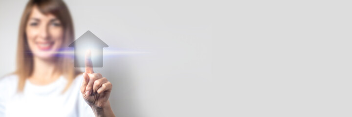young girl points and clicks a finger on a virtual house, an icon is added on a light background. Banner. Concept business, home, real estate, future technology