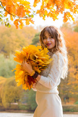 Beautiful girl with autumn leaves. October photos of autumn.