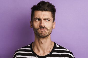 Photo of brooding young man posing and looking aside