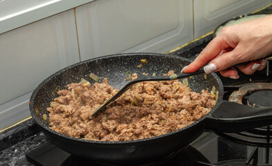 Cooking minced meat for pancakes with meat.