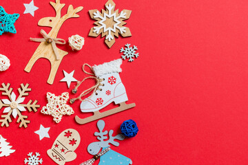 Top view of holiday toys and decorations on red Christmas background. New Year time concept with copy space