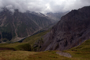 Fototapeta premium Peaks and slopes of mountains in foggy weather. Elbrus region near the village of Terskol. Caucasus, Russia.