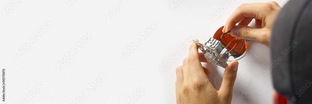 Poster electrician installing light switch on painted wall with screwdriver. man installing light switch af