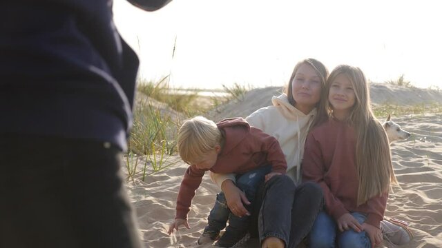 photographer shoots family in autumn on the sand by the sea