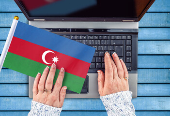 woman hands and flag of Azerbaijan on computer, laptop keyboard 