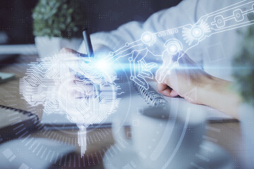 Multi exposure of writing hand on background with brain hologram. Concept of self learning.