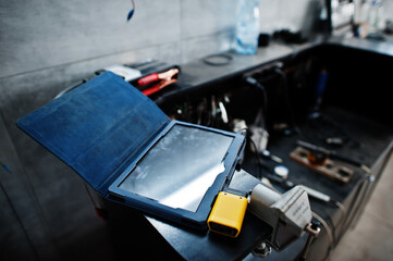 Car repair and maintenance theme. Tablet with tools in auto service.