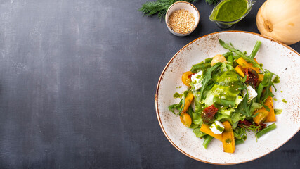 Delicious pumpkin salad with fried tomatoes. Top view, text space