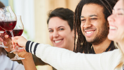 Friends sit together at home with a glass of red wine in a shared apartment