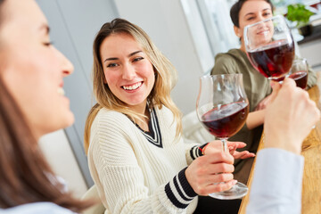 Group of women talking as friends over glass of red wine