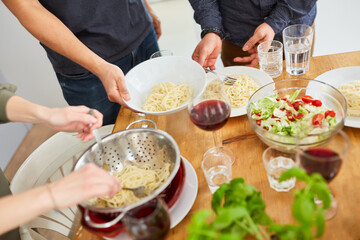 Serve spaghetti from sieve for meal on a set dining table with salad
