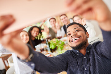 Man makes selfie or video call with friends while eating together