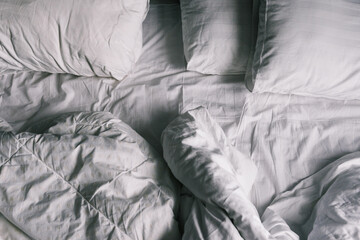 Unmade bed. Rumpled sheets and pillows after a night's sleep. The view from the top. Dirty white bed linen