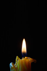 Single candle light on a black background. Burning candle close up