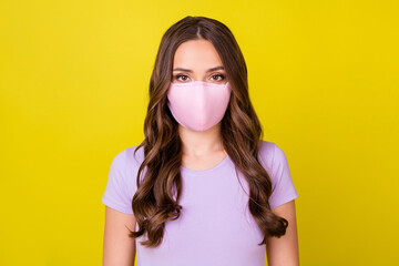 Close-up portrait of attractive healthy wavy-haired girl wearing textile mask isolated over bright...