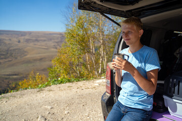 young man is resting in nature with an off-road vehicle