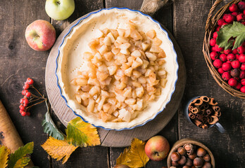 Baking background with raw traditional classic apple pie, bake  ingredients and utensils. Homemade  cake surrounded by fresh fruits