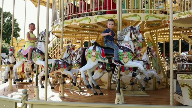 Children Ride On A Carousel In The Park