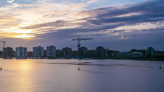 Time lapse of indigo nightfall over cityscape by wide river